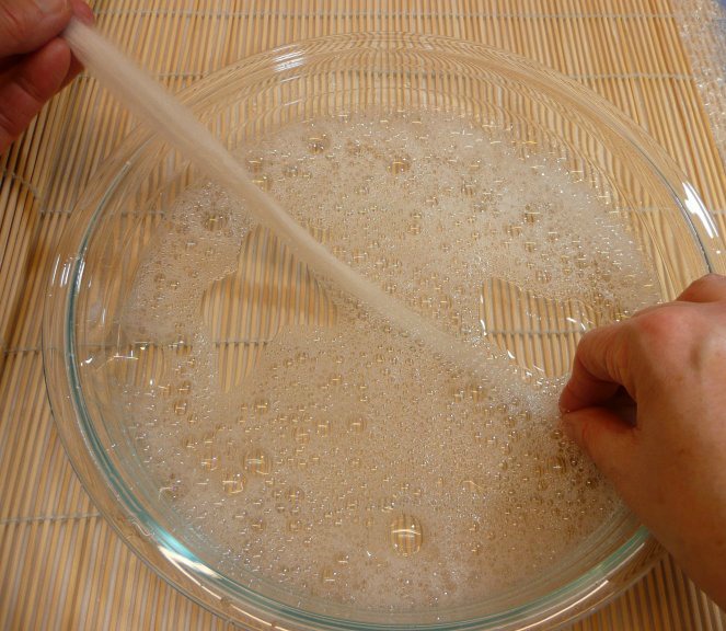 Pulling wool through soapy water