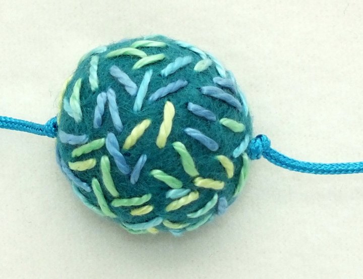 Felt bead with knots either side